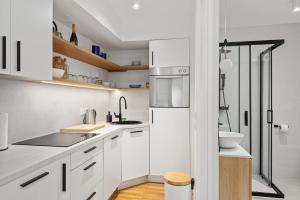 uma cozinha branca com uma pia e uma geladeira em M2 Modern Apartment in City Center em Zagreb