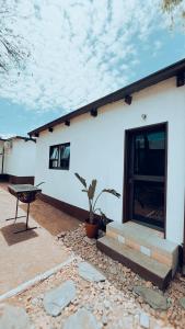 a white house with a bench in front of it at Central Nomad Apartment in Windhoek