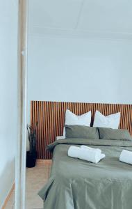 a bed with two white towels on top of it at Central Nomad Apartment in Windhoek