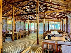 a dining room with wooden tables and chairs at Bruce House in Nonthaburi