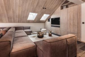 a living room with a couch and a tv at Antarès SIRIUS 503 - Spacious ski inski out apartment in Méribel