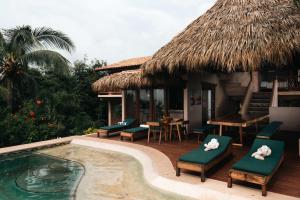a resort with a pool and chairs and a table at Casa Playa Verde - 200Mbps Wifi in Troncones