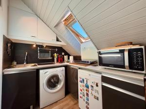 une cuisine avec un lave-linge et un micro-ondes dans l'établissement Studio 2 personnes Proche Centre-Ville, à Besançon