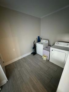 una lavanderia vuota con lavatrice e asciugatrice di Haute on Hannon- Midtown Cottage! a Mobile