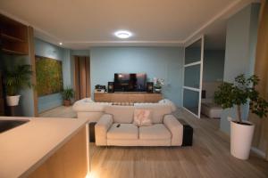 a living room with a couch and a tv at Vila Luarasi Blue Apartment in Kaninë