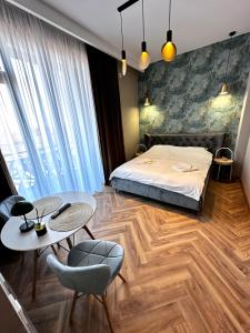 a bedroom with a bed and a table and chairs at MK Apart Boutique 2 in Voluntari