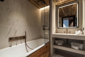 a bathroom with a tub and a sink at Antarès SIRIUS 302 - Ski inski out family apartment in Méribel
