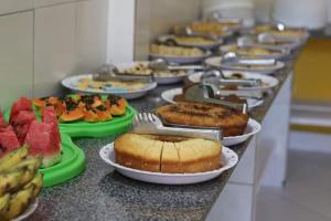 a bunch of food on a counter with plates of food at Pousada Beija flor in Morro de São Paulo