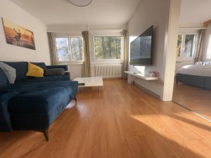 a living room with a blue couch and a bed at Center, Sauna, View - Haus LINARIA in Leukerbad