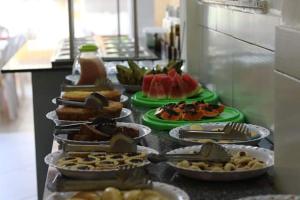 a buffet with several plates of food on a counter at Pousada Beija flor in Morro de São Paulo