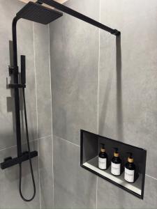 a shower with three bottles on a shelf in a bathroom at Bonheur Luxury Rooms in Ercolano