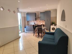 a living room with a blue couch and a kitchen at Casa Ludovica Centocelle in Rome