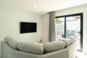 a living room with a couch and a flat screen tv at Star House -Jacuzzi & Aircon in Calheta