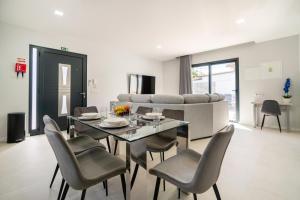 a dining room with a table and chairs and a couch at Star House -Jacuzzi & Aircon in Calheta