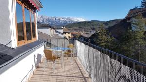 einen Balkon mit einem Tisch und Stühlen auf einem Gebäude in der Unterkunft Hotel Meson de L’Ainsa in Aínsa