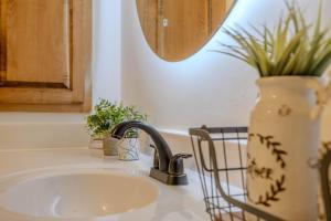 a kitchen sink with a faucet and a mirror at Osprey - Family Cabin, Hot Tub, Game Room, Theater in Blairsville +58 photos