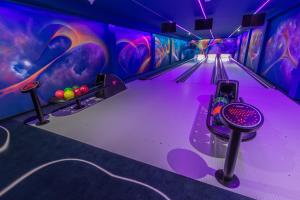 a bowling alley with purple lanes and balls at Borowy Dwór- Biznes, Spa & Fun in Szaflary +125 photos