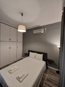 ein Schlafzimmer mit einem großen weißen Bett und einem Ventilator in der Unterkunft MP Studios in Artemida