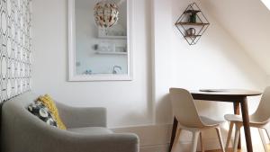 a living room with a chair and a table and a lamp at Peterborough House in Saint Aubin