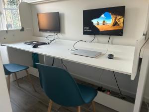 a desk with a laptop and a monitor on it at Canyelles BBQ Apartment in Lloret de Mar