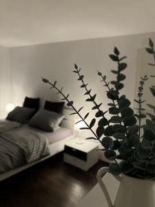 a bedroom with a bed and a vase with a plant at WEIDEN51 - Apartment für Business & Familien in Fürstenfeldbruck