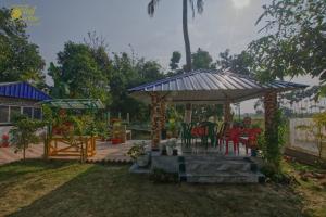 a gazebo with chairs and tables in a yard at Greenview Haven in Gobārdānga +7 photos