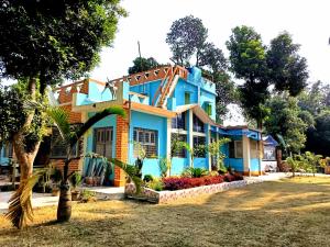 a blue house with a palm tree in front of it at Greenview Haven in Gobārdānga