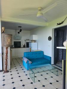 un soggiorno con un divano blu e un tavolo di Villa cosy a Sainte-Luce Altre 17 foto