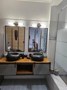 un bagno con due lavandini e due specchi di Villa cosy a Sainte-Luce