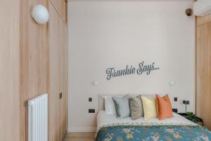- une chambre avec un lit et des oreillers colorés dans l'établissement Soho Swank - by Frankie Says, à Londres