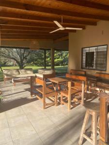 un patio con tavoli e panche in legno e finestre di Linda casa a metros del río Paraná con pileta a Ituzaingó