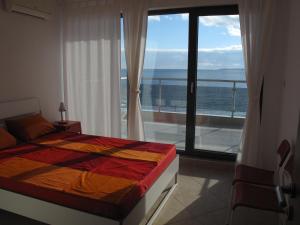 a bedroom with a bed and a view of the ocean at The Beach House in Sozopol