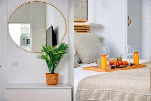 - un miroir sur un mur au-dessus d'un lit avec un plateau de fruits dans l'établissement 402 Suite Netter - Superbe Studio à Paris, à Paris