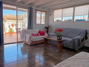 a living room with a couch and a table at Centrico Atico Apt Sleeps 4 with Patio in Almuñécar +11 photos
