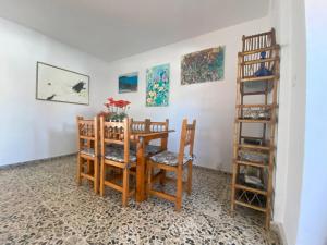 a dining room with a table and chairs and paintings at Centrico Atico Apt Sleeps 4 with Patio in Almuñécar