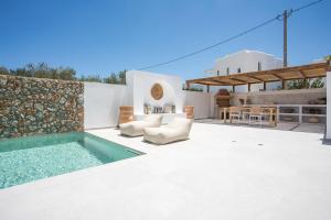 a patio with a swimming pool and a house at Zaia Suites & Living , Suite N6 , sea side view in Gennadi