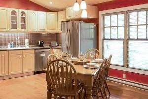 eine Küche mit einem Tisch mit Stühlen und einem Kühlschrank in der Unterkunft 2BR Cottage Surrounded by Nature in Tobermory + 13 Fotos