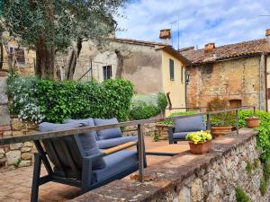 チェトーナにあるLa Terrazza, historic Tuscan stone residence with garden and terrace in Cetonaの石の壁の上に椅子が2脚置かれたパティオ