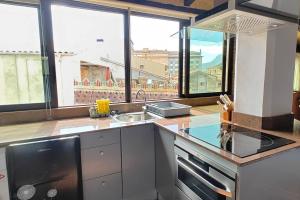 a kitchen with large windows and a counter with a sink at TAO casa WOOD apartamentos in Olot +4 photos