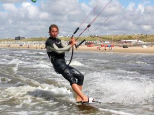 a man on a surfboard in the water at Divi Divi Zandvoort in Zandvoort