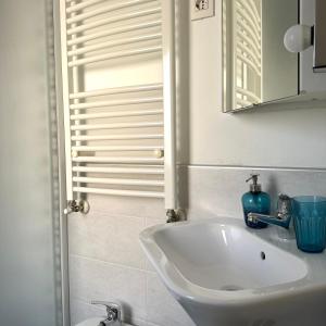 Un baño con un lavabo blanco y un espejo. en ForumGuestHouse Center Parking, en Parma