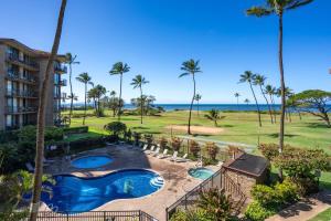 an aerial view of a resort with a swimming pool and palm trees at Deluxe Oceanside Resort Vistas in Kihei