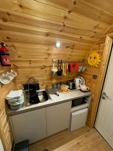 a small kitchen with a sink and a stove at Fat Pete's Pod in Norwich +13 photos
