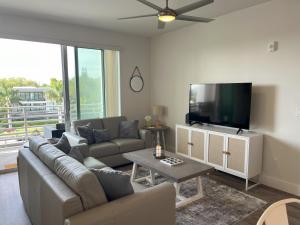 a living room with a couch and a flat screen tv at Luxury 2 Bed 2 Bath Waterfront Condo with Patio Sunsets Gym and Parking in Sarasota +27 photos