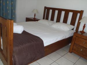 a bedroom with a bed with white sheets and pillows at Beachside Holiday Units in Bowen