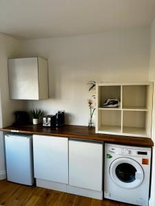 eine Küche mit Waschmaschine und Trockner auf der Theke in der Unterkunft Urban Studio Finchley in Finchley + 6 Fotos