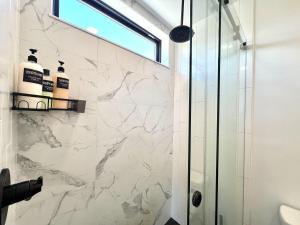 a bathroom with a shower and marble walls at Hidden Abode in Orderville