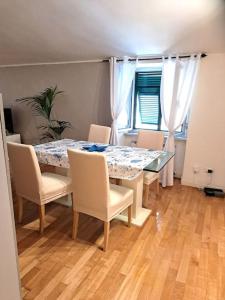 a dining room with a table and chairs and a window at La Mansarda di Ale in La Spezia