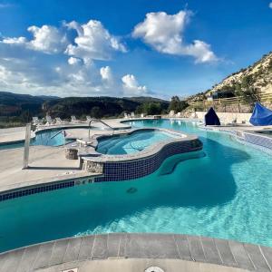 a group of three swimming pools with blue water at Valley View in Orderville