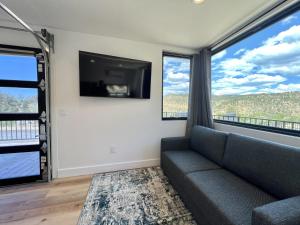 a living room with a couch and a flat screen tv at Iron Cliff in Orderville